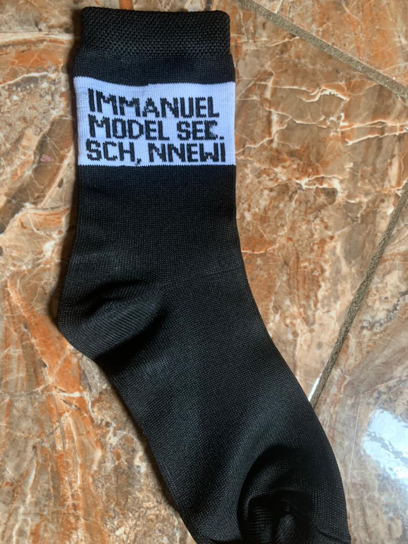 Black school sock with a white panel reading Immanuel Model Secondary School Nnewi