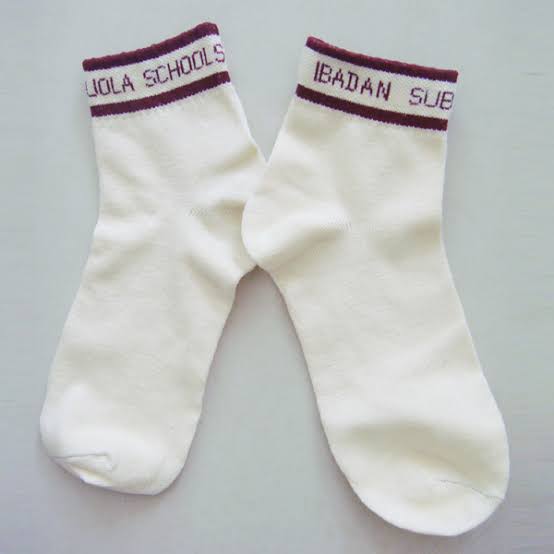 Cream school socks with a maroon welt reading Loyola Schools Ibadan
